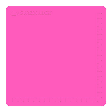 Hot glue gun hovers over a large pink Surebonder silicone pad, measures 19 inches by 19 inches