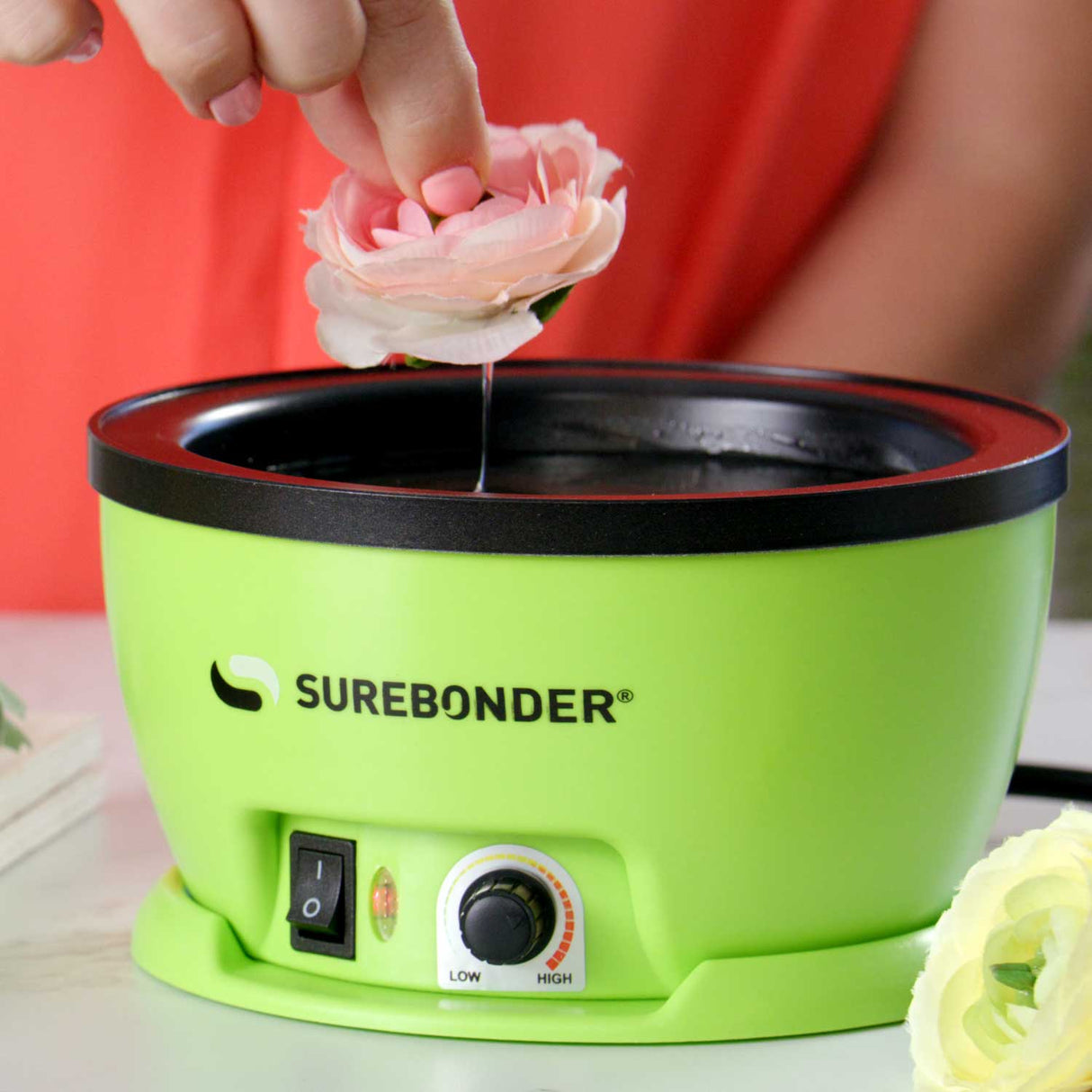 flower being dipped into skillet with melted glue pellets ready to place onto project