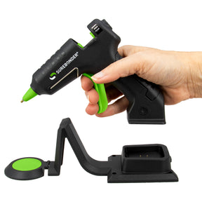 Black and green Surebonder glue gun held by a hand on a white background