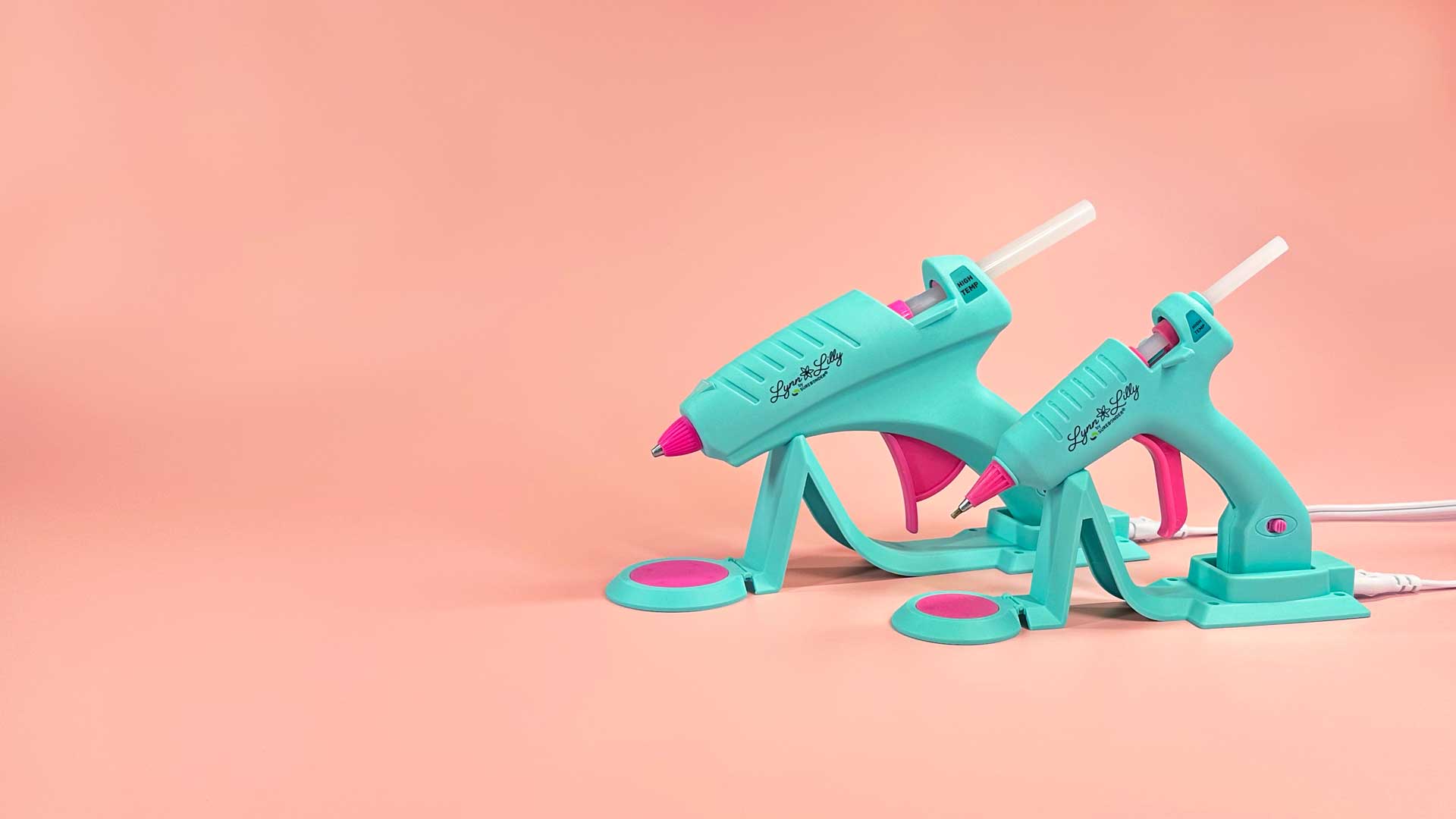 Lynn Lilly glue guns sitting together on a pink background