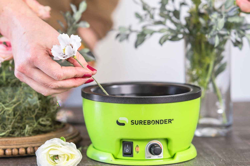 white flower dipping into the Surebonder adjustable temperature glue skillet